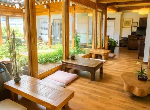Bright interior of Cha Masineun Tteul tea house in Bukchon Hanok Village, featuring wooden tables, natural light, and a peaceful garden view