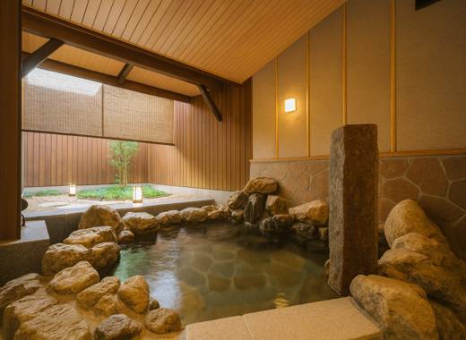 쿄토 호텔 교토 우메코지 카덴쇼 실내 온천탕, 돌담과 따뜻한 조명 아래 교토식 정원을 바라보는 일본식 대욕장
