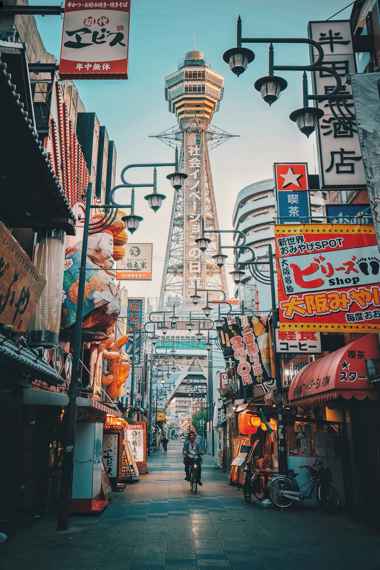 Osaka Tsutenkaku Tower street view with local shops and evening lights