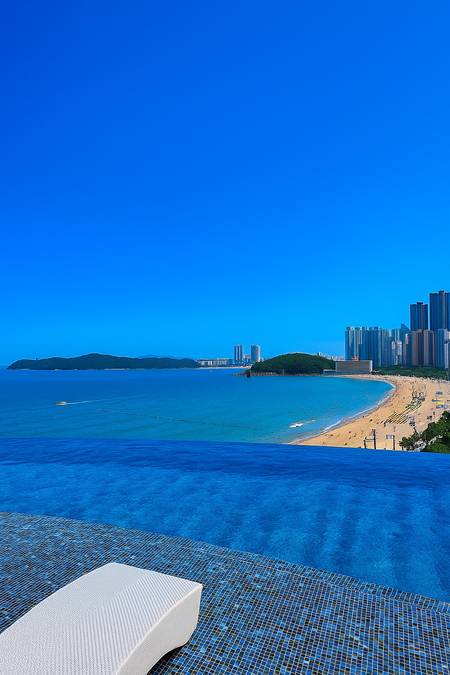 Infinity pool view from Signiel Busan overlooking the beach and city skyline on a clear day