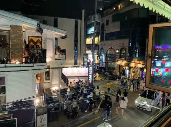 Night view of Apgujeong Rodeo Street with crowded restaurants and neon lights, showing the vibrant atmosphere around Apgujeong Rodeo Street restaurants in Seoul.