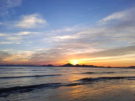 Sunset at Dadaepo Beach during a Busan travel experience, with calm waves and a golden sky