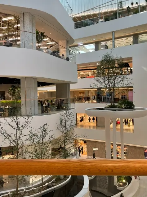 Interior view of The Hyundai Seoul mall located near Conrad Seoul, with open atrium design and multiple shopping floors