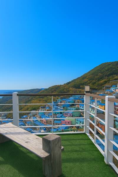 A scenic view of Gamcheon Culture Village from Sky Maroo Observatory with scattered clouds and vibrant town colors