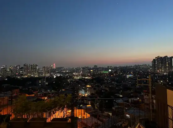 Haebangchon food guide night view overlooking the Seoul skyline at dusk, peaceful cityscape for foreign travelers