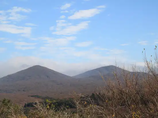 Mountain view from Hallasan Dullegil Route 2 Doloreum Trail in Jeju, showing wide volcanic terrain under a clear sky.