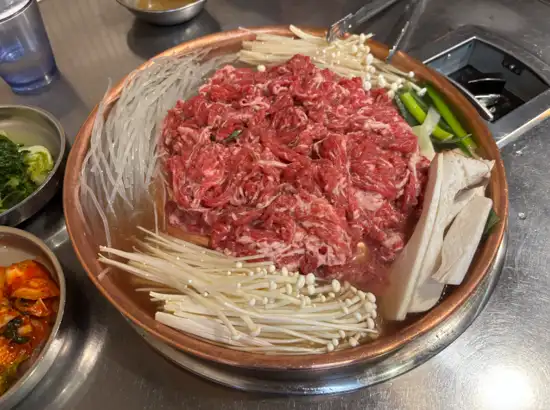 Korean old-style bulgogi with mushrooms and vegetables served in a traditional pan at a restaurant in Gongdeok, featured as part of the Haneul Park Seoul Travel Course.