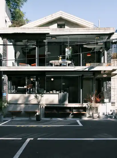 Modern two-story glass café near Hyochang Park, featuring an open façade, minimal design, and bright interior seen from the street.