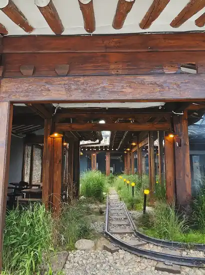 Insadong travel scene featuring a traditional Korean hanok corridor with wooden beams, warm lanterns, and a peaceful garden path.