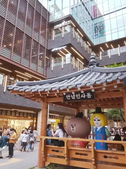 Insadong travel scene featuring a hanok-style pavilion with character figures in Seoul’s modern shopping district.
