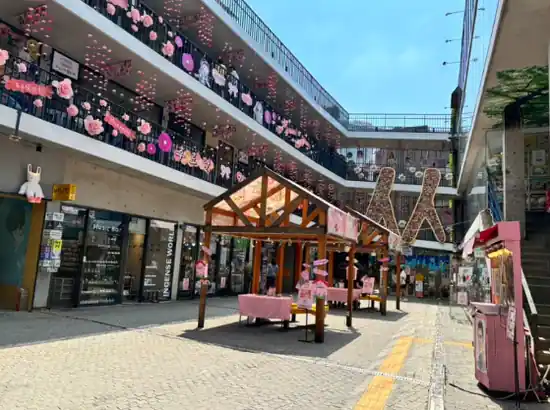Insadong travel scene showing Ssamziegil’s decorated courtyard with colorful hanging ornaments and small wooden market stalls.