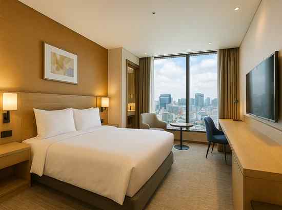 Novotel Ambassador Seoul Dongdaemun room interior with warm wood tones and a city view window.
