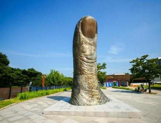 Large thumb sculpture at Olympic Park Seoul under blue sky, one of the symbolic artworks in the outdoor sculpture garden.