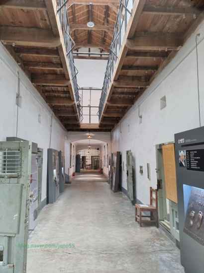 Main hallway exhibit at Seodaemun Prison History Hall showing preserved prison cells, wooden upper walkway, and historical displays.