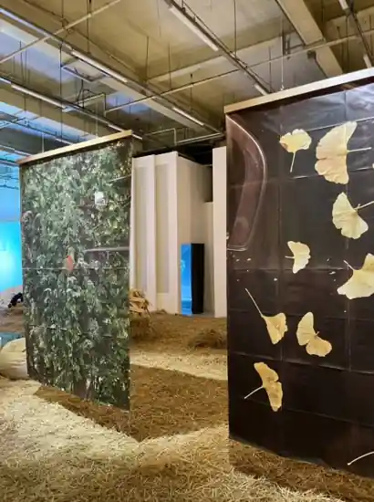 Art installation at a Seongsu exhibition space featuring large hanging prints and straw-covered floor — Seongsu travel experience.