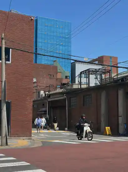 A street scene in Seongsu, Seoul, featuring red brick buildings, a rider on a scooter, and a clear blue sky — Seongsu travel atmosphere.