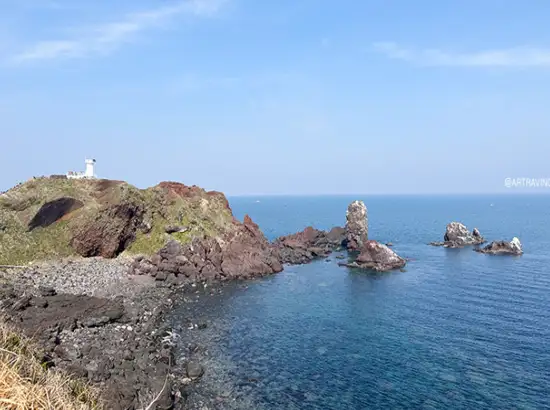 Seopjikoji travel view of volcanic coastal cliffs and the deep blue Jeju sea under a clear sky.