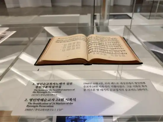 Hymnal book displayed inside Seosomun Shrine History Museum with explanatory text in Seoul