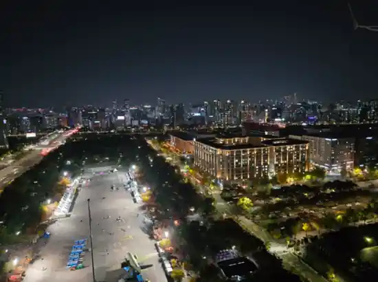 Night city view of Yeouido seen from Seoul Dal, showing illuminated buildings, park area, and skyline under a dark sky.