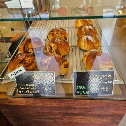 Fresh cinnamon and cardamom buns displayed at a local bakery near the Seoul Dulle-gil 15 Course, showing warm golden textures inside the café.