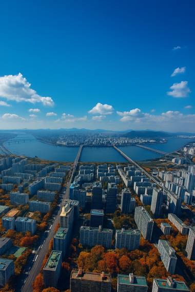 Aerial view of Han River and Seoul cityscape with autumn foliage trees near Signiel Seoul hotel under a bright blue sky