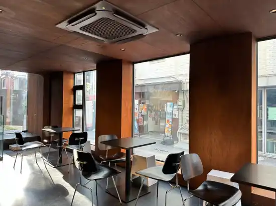 Interior view of Morning Calm Coffee Lab featured in the Yeonnam-dong One-Day Course, showing quiet seating, warm wooden walls, and soft natural light.