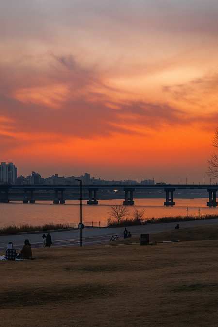 Yeouido Hangang Park sunset view with the Han River, evening sky colors, and Seoul city skyline.
