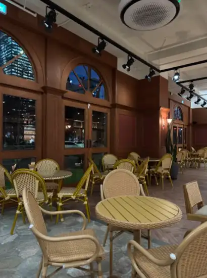 Interior view of a cozy cafe near the Yeouido Park walking course, featuring warm lighting and woven chairs at Michele Coffee.
