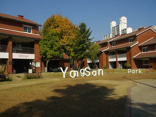 Yongsan Family Park lawn and red-brick buildings on a sunny day in Seoul