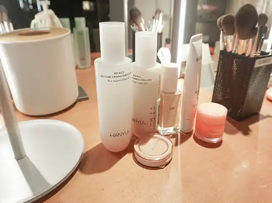 Skincare and makeup products arranged for the Amore Seongsu K-Beauty Makeup Class, featuring Hanyul and Laneige items on a vanity table.