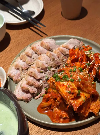 apgujeong food – sliced bossam pork with spicy kimchi on a plate