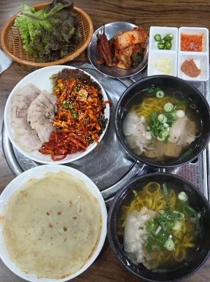 apgujeong food – bossam pork set with noodles, kimchi, and side dishes on a tray