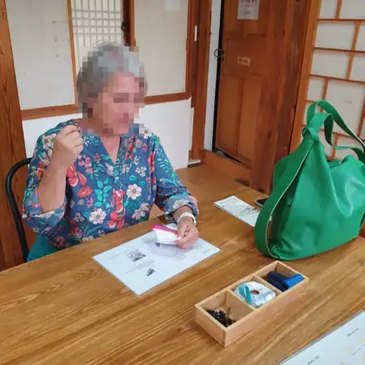 Bukchon Traditional Craft Experience workshop in a Korean hanok, foreign visitor learning traditional craft techniques