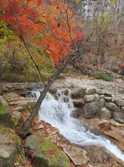 Small waterfall and autumn foliage near Ui Valley on the Bukhansan Pine Forest Trail in Seoul.
