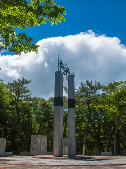Independence memorial monument surrounded by forest at the starting point of the Hallasan Dongbaek-gil trekking route in Jeju.