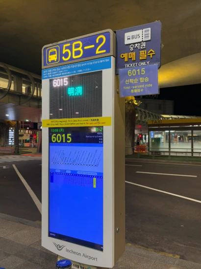 Incheon Airport to Myeongdong Airport Bus 6015 stop sign at Terminal 1 (5B-2) with timetable display