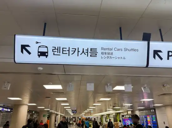 Jeju Airport rental car shuttle sign for international travelers using Jeju car rental for foreigners
