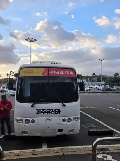 JejuYouCar shuttle bus waiting at Jeju Airport for international travelers using Jeju car rental for foreigners