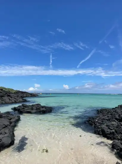 Clear turquoise water and black volcanic rocks at Jeju Hamdeok Beach, captured for the Jeju Hamdeok Beach Travel Guide.
