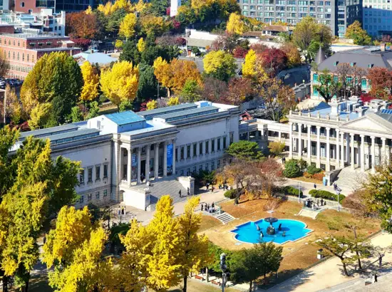View of Deoksugung museum buildings and central fountain captured from Jeongdong Observatory visit guide viewpoint during autumn season