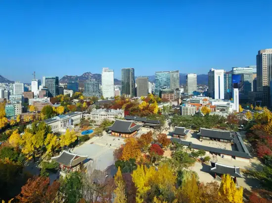 Panoramic autumn view of Deoksugung Palace and Seoul skyline seen from Jeongdong Observatory visit guide viewpoint