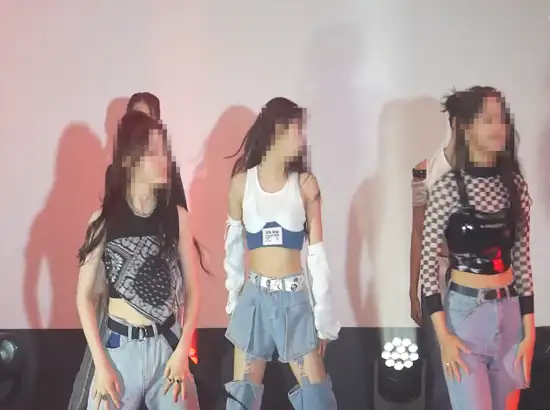 Dancers performing choreography under stage lighting during a K-POP Dance Class Seoul session, showcasing energetic K-pop movement and group formation.