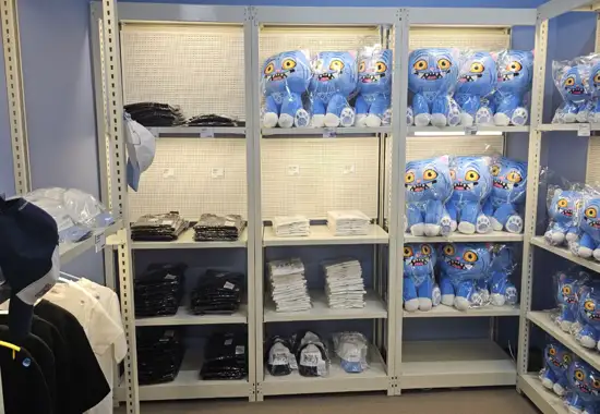 K-Pop Demon Hunters Pop-Up Store merchandise shelf display featuring plush items and folded clothing arranged inside Seoul event space