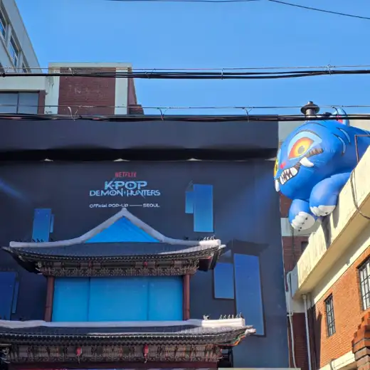 K-Pop Demon Hunters Pop-Up Store main front entrance in Seoul Seongsu, event signage with character figure displayed
