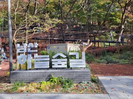 namsan sky forest trail itinerary sign at Namsan Sky Forest Trail entrance with boardwalk and autumn trees in Seoul