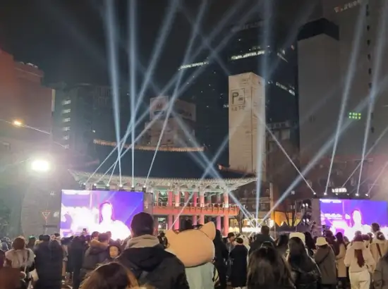 Crowd gathered at Boshingak during the New Year Bell-Ringing Ceremony in Seoul, with stage screens and night lights illuminating the event