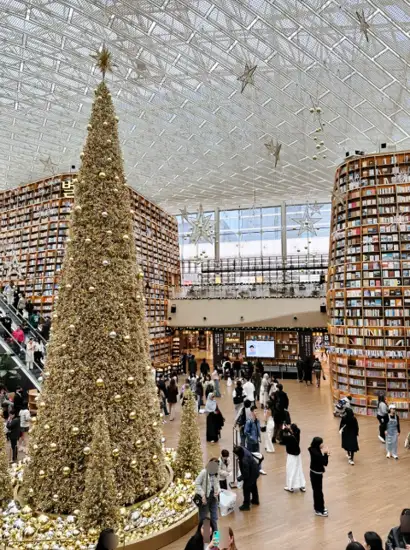 Starfield Library decorated with a large golden Christmas tree inside COEX Mall, near SEA LIFE COEX Aquarium in Seoul.