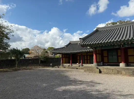 Traditional cultural hall with Korean tiled roof architecture inside Seongeup Folk Village, Jeju, Korea