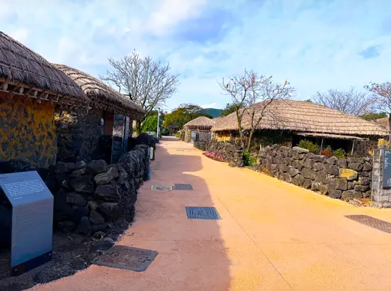 Traditional thatched houses and stone walls path in Seongeup Village Traditional House area in Jeju