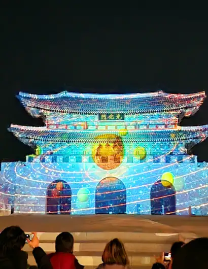 Seoul Light Gwanghwamun media facade show at night with illuminated palace structure and visitors watching the projection mapping display